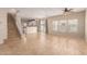Spacious living room with tiled floors, neutral walls, ceiling fan, and abundant natural light from the sliding glass door at 6337 W Valencia Dr, Laveen, AZ 85339