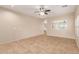 Spacious living room with tiled floors, neutral walls, ceiling fan, and abundant natural light from the windows at 6337 W Valencia Dr, Laveen, AZ 85339