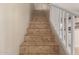 Tile staircase with white railing leads to the upper level with beige walls at 6337 W Valencia Dr, Laveen, AZ 85339