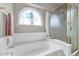 Clean bathroom featuring bathtub, large window, and walk-in shower with glass doors at 6915 E Lakeview Ave, Mesa, AZ 85209