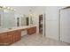 Open bathroom boasts a double vanity, glass shower, and bathtub for convenience and relaxation at 6928 W Oraibi Dr, Glendale, AZ 85308