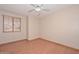 This bedroom features wood laminate flooring, a window with blinds, and a ceiling fan at 6928 W Oraibi Dr, Glendale, AZ 85308