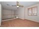 This airy bedroom features a window, ceiling fan, and wood laminate flooring at 6928 W Oraibi Dr, Glendale, AZ 85308