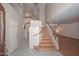 Bright, open foyer with wood-look flooring, staircase, and high ceilings at 6928 W Oraibi Dr, Glendale, AZ 85308