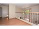 Upstairs hallway with wood flooring, white railings overlooking the living room at 6928 W Oraibi Dr, Glendale, AZ 85308