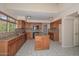 Spacious kitchen with a granite island, black appliances, and beautiful tile floors at 6928 W Oraibi Dr, Glendale, AZ 85308