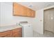 Practical laundry room with upper cabinets, folding counter, and efficient washer at 6928 W Oraibi Dr, Glendale, AZ 85308