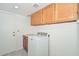 Functional laundry room with upper cabinets, counter space, and modern washer at 6928 W Oraibi Dr, Glendale, AZ 85308