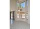Sunlit living room with soaring ceilings, tile floors, and access to outdoor spaces at 6928 W Oraibi Dr, Glendale, AZ 85308