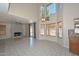 Bright living room featuring a fireplace, soaring windows, neutral walls, and tile flooring at 6928 W Oraibi Dr, Glendale, AZ 85308
