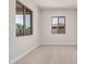 Bright living room featuring light-colored wood-style flooring and two windows at 6952 E Brushy Bill Rd, San Tan Valley, AZ 85143