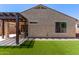 Backyard features artificial grass, pavers and a pergola for shade at 7086 W Spur Dr, Peoria, AZ 85383