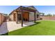Backyard showcasing a covered patio and an artificial grass lawn perfect for outdoor living at 7086 W Spur Dr, Peoria, AZ 85383