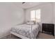Bright bedroom with a white metal frame bed, side table, and window with lots of light at 7086 W Spur Dr, Peoria, AZ 85383
