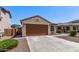Single-story home featuring a two-car garage, desert landscaping, and a neutral color palette at 7086 W Spur Dr, Peoria, AZ 85383