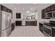 Spacious kitchen featuring stainless steel appliances, dark wood cabinets, and granite countertops at 7086 W Spur Dr, Peoria, AZ 85383