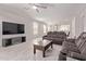 Modern living room featuring tile floors, media center, ceiling fan, and reclining sofa at 7086 W Spur Dr, Peoria, AZ 85383