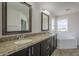 Bathroom featuring double sinks, granite countertop, a bathtub, and great natural light from the windows at 8518 S 8Th Ln, Phoenix, AZ 85041