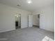 Carpeted bedroom featuring an ensuite bathroom and hallway access at 8518 S 8Th Ln, Phoenix, AZ 85041