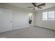 Spacious bedroom featuring carpet flooring, ceiling fan, and a view into the en-suite bathroom at 8518 S 8Th Ln, Phoenix, AZ 85041