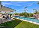 Spacious backyard featuring a pool, covered patio, built-in grill, and mature landscaping at 8730 E Montecito Ave, Scottsdale, AZ 85251