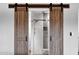 Charming primary bathroom featuring sliding barn doors and modern shower design at 8730 E Montecito Ave, Scottsdale, AZ 85251