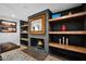 Close up of the fireplace featuring wooden shelving, and a beautiful mirror at 8730 E Montecito Ave, Scottsdale, AZ 85251
