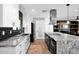 Renovated kitchen features white cabinets, stainless steel appliances and black backsplash at 8730 E Montecito Ave, Scottsdale, AZ 85251