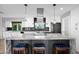 Kitchen island with barstool seating and stainless steel hood and appliances at 8730 E Montecito Ave, Scottsdale, AZ 85251
