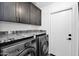 Efficient laundry room with front loading washer, dryer and granite countertops at 8730 E Montecito Ave, Scottsdale, AZ 85251
