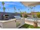 Built-in outdoor grill with stainless steel appliances, counter space, and view of the pool at 8730 E Montecito Ave, Scottsdale, AZ 85251