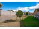 Large backyard with a green grass area, gravel landscaping, and block wall fencing at 8828 E Des Moines St, Mesa, AZ 85207