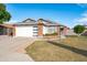 Single-story home featuring a modern garage door, well-kept lawn, and brick details at 8828 E Des Moines St, Mesa, AZ 85207