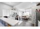 Bright, open kitchen with white cabinetry and modern appliances, adjacent to a dining area at 8828 E Des Moines St, Mesa, AZ 85207