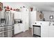 Well-lit kitchen featuring stainless steel appliances, white cabinetry, and tile flooring at 8828 E Des Moines St, Mesa, AZ 85207