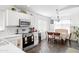 Bright kitchen and dining area features white cabinetry, stainless appliances, and stylish tile flooring at 8828 E Des Moines St, Mesa, AZ 85207