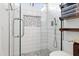 Modern bathroom shower with sleek tilework, glass enclosure, and convenient shelving at 8828 E Des Moines St, Mesa, AZ 85207