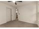Bright bedroom with carpeted floor, ceiling fan, and closet with a bathroom visible through the door at 908 W Mohawk Ln, Phoenix, AZ 85027