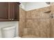 Shower features stone tile, built-in shelf and bench seating for a luxurious and convenient bathing experience at 908 W Mohawk Ln, Phoenix, AZ 85027