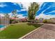 Spacious backyard featuring lush artificial turf, mature trees, and colorful flowerbeds at 9265 E Kalil Dr, Scottsdale, AZ 85260