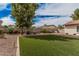 Expansive artificial grass backyard with mature landscaping, and rock accents at 9265 E Kalil Dr, Scottsdale, AZ 85260