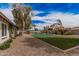 Lush backyard featuring a sparkling pool, ample green space, and privacy fence for outdoor enjoyment at 9265 E Kalil Dr, Scottsdale, AZ 85260