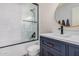 Updated bathroom showcases a glass-enclosed shower, patterned walls, and a stylish blue vanity at 9265 E Kalil Dr, Scottsdale, AZ 85260