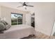 Bright bedroom featuring a ceiling fan, sliding glass door, and a glimpse into the closet at 9265 E Kalil Dr, Scottsdale, AZ 85260