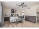 Spacious bedroom featuring a ceiling fan, a relaxing chair, and a view into the bathroom at 9265 E Kalil Dr, Scottsdale, AZ 85260