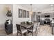 Stylish dining room with a gray wooden table, seating for six, modern chandelier and adjacent kitchen at 9265 E Kalil Dr, Scottsdale, AZ 85260