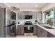 Modern kitchen featuring gray cabinetry, stainless steel appliances, and ample countertop space at 9265 E Kalil Dr, Scottsdale, AZ 85260