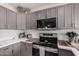 Modern kitchen featuring gray cabinets, white countertops, mosaic backsplash, and stainless steel appliances at 9265 E Kalil Dr, Scottsdale, AZ 85260
