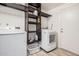 Bright laundry room with wood shelving, modern appliances, and light-colored flooring at 9265 E Kalil Dr, Scottsdale, AZ 85260