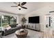 Comfortable living room with a gray couch, a large TV, a ceiling fan, and natural light from the window at 9265 E Kalil Dr, Scottsdale, AZ 85260
